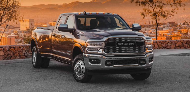 Ram 3500 heavy-duty pickup parked against a scenic mountain city backdrop at sunset
