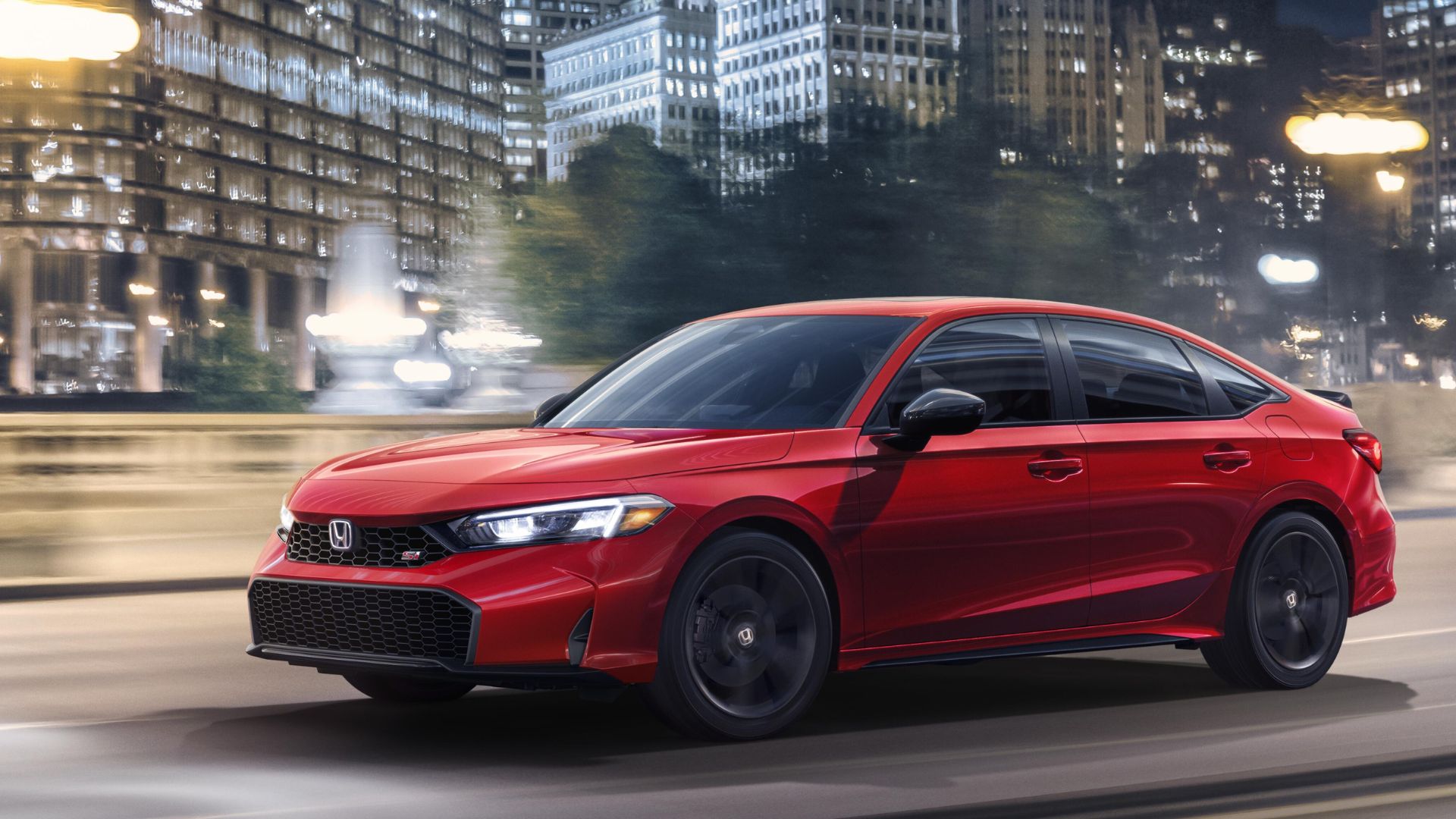 Red Honda Civic Si speeding through a city street, highlighting its sporty styling and performance design