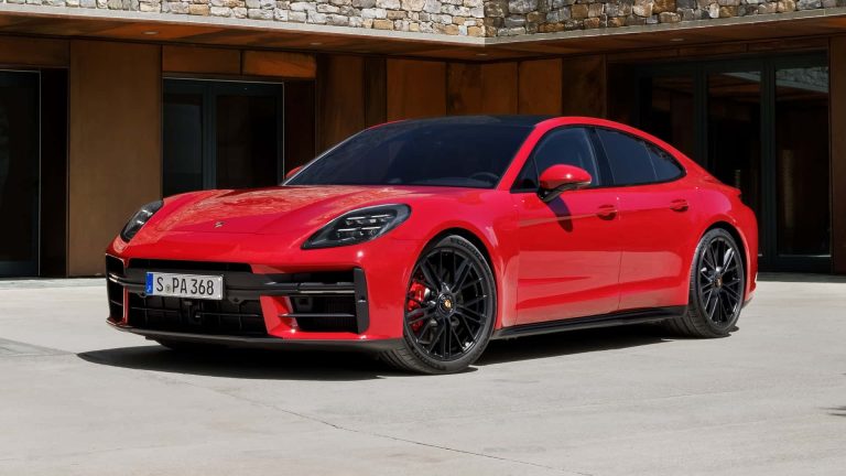Red Porsche Panamera parked outside a modern residence, showcasing its sleek luxury sedan styling