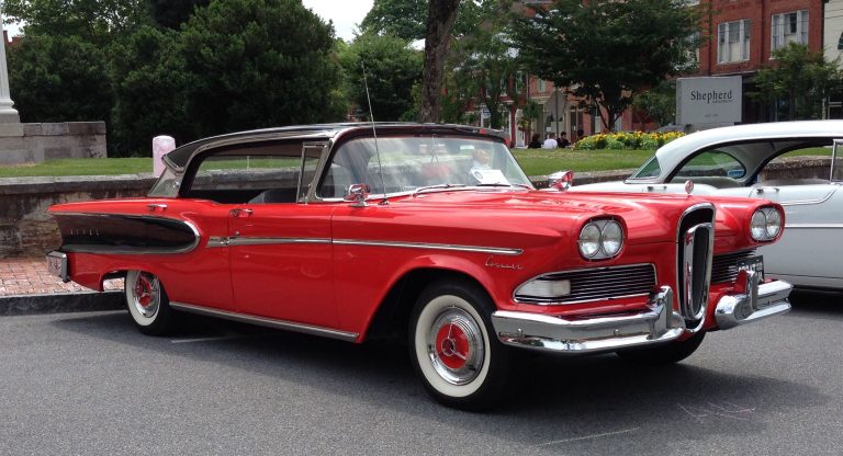 Red vintage Ford Edsel convertible displayed outdoors, featuring distinctive vertical grille styling and classic chrome details