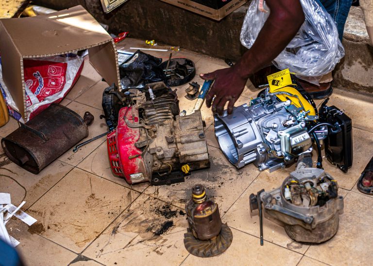 Many engine parts are lying on the ground for replacement of transmission