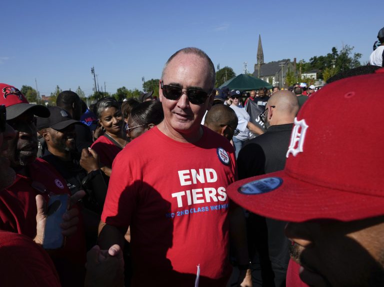 Shawn Fain, United Auto Workers president, wearing a red “End Tiers” shirt at a public gathering