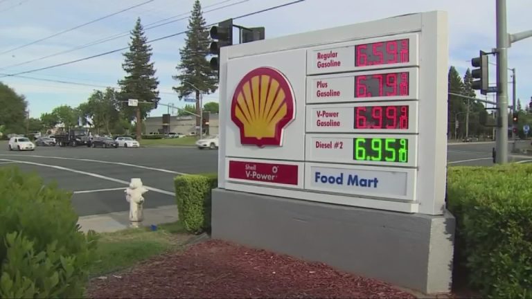 Shell gas station price sign displaying regular, plus, premium gasoline, and diesel prices at a roadside intersection