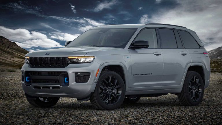 Silver Jeep Grand Cherokee 4xe parked on rocky terrain beneath dramatic skies, highlighting its rugged styling