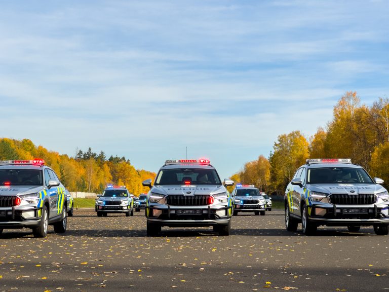 Many police cars are standing in an open road