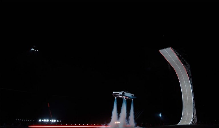 Tesla Roadster prototype appears airborne during a nighttime demonstration, showcasing its thruster technology