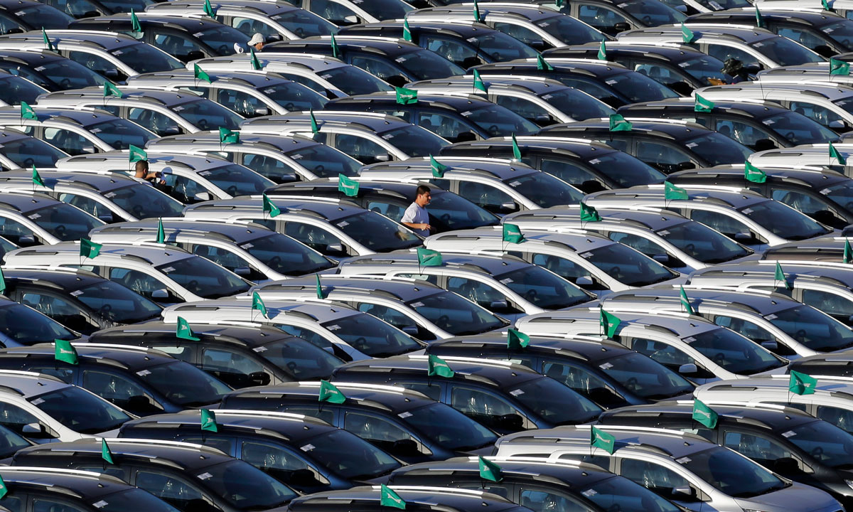 Thousands of GM vehicles sit tightly packed in storage lots, awaiting parts and final assembly