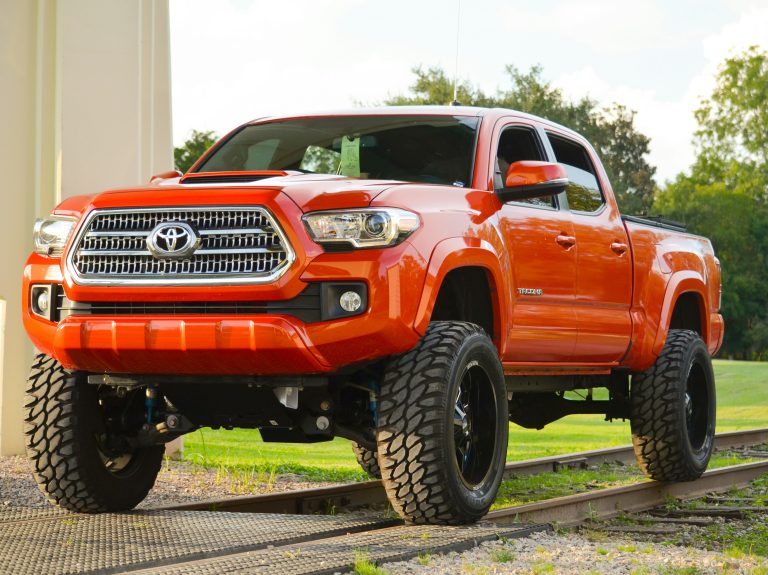 A Tacoma is standing on a railway track on a sunny day