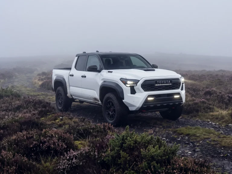 A Tacoma is off roading on a muddy patch on a foggy day