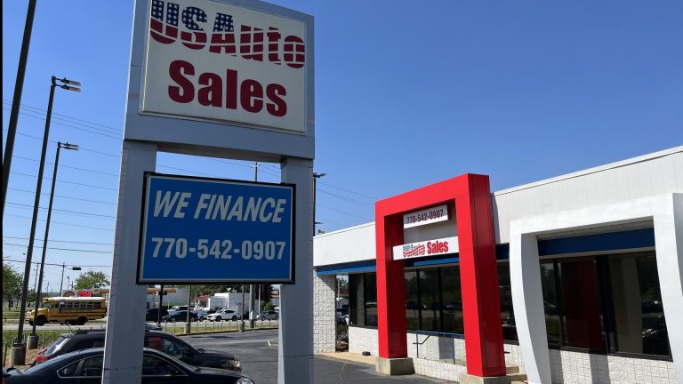 USA used car dealership with financing sign and vehicles visible in the lot