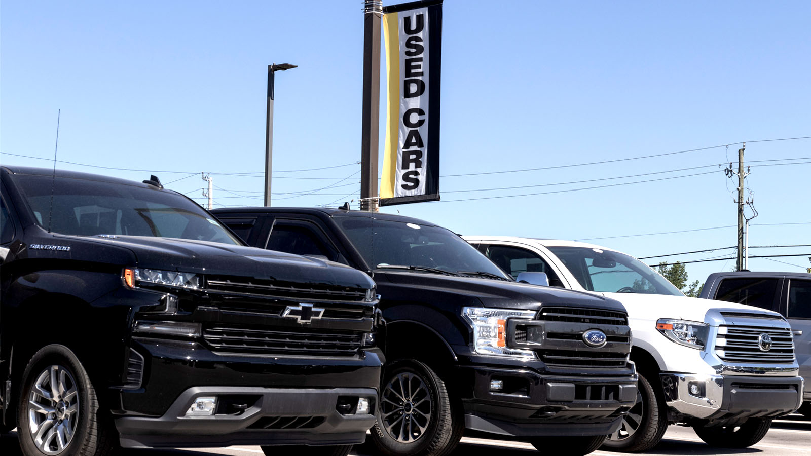 Used Chevrolet Silverado, Ford F-150, and Toyota Tundra pickup trucks displayed at a dealership
