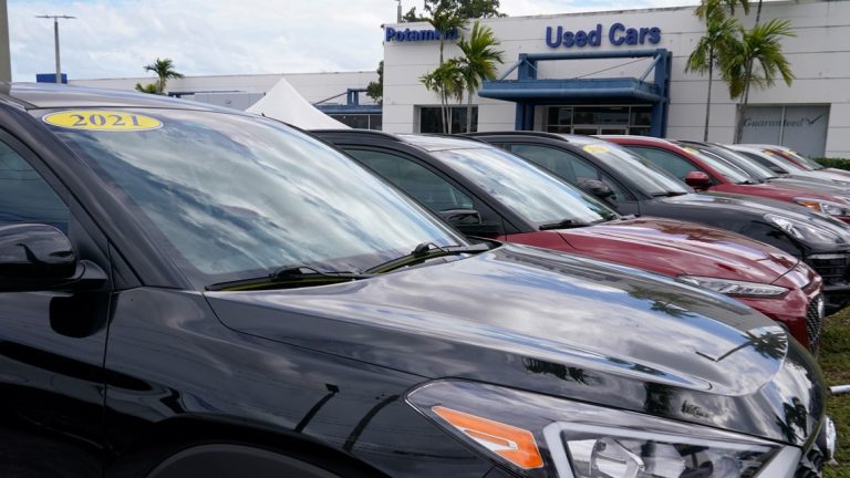 Used cars lined up outside a dealership, showcasing various models available for purchase