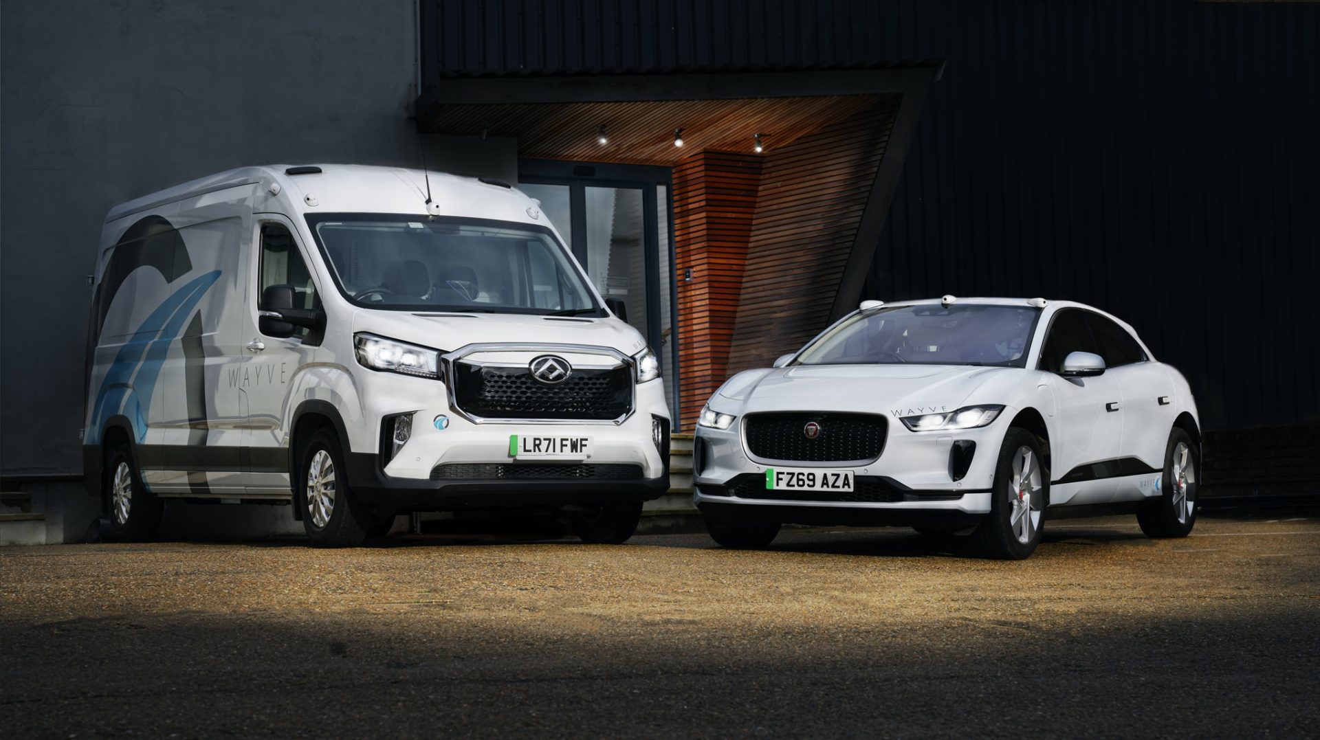 Wayve autonomous driving technology showcased through a white van and electric SUV