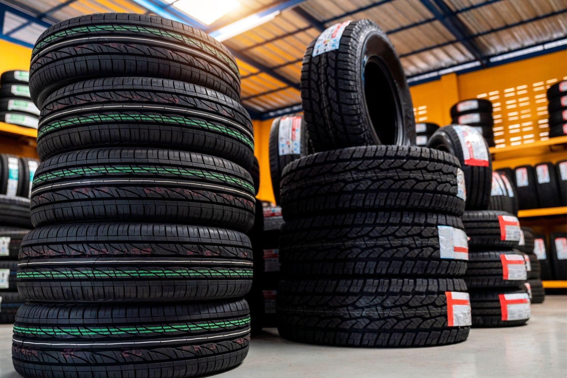 Stacks of new tires displayed inside a tire shop
