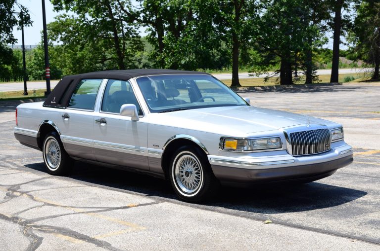 White 1990 Lincoln Town Car parked outdoors, featuring its classic chrome grille and elegant vinyl roof