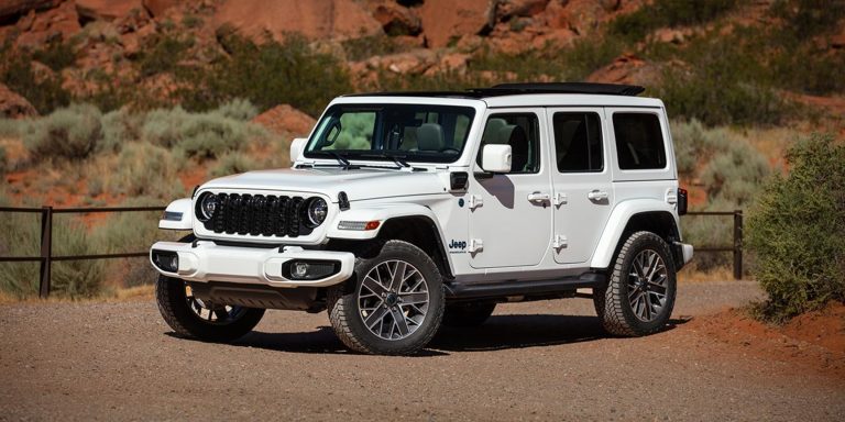 White Jeep Wrangler parked on rugged terrain, highlighting its iconic off-road design and capabilities