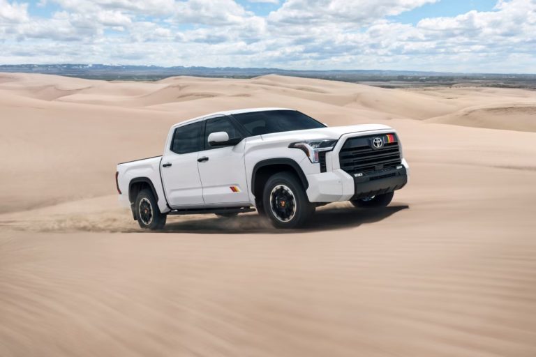 White Toyota Tundra TRD Rally package driving across sandy dunes, showcasing its rugged off-road styling