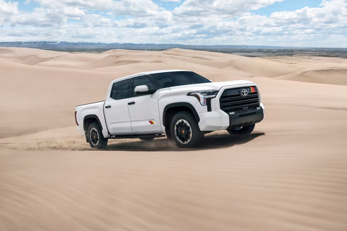 White Toyota Tundra TRD Rally package driving across sandy dunes, showcasing its rugged off-road styling