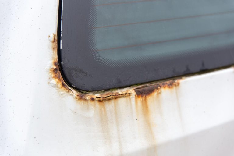 A rusty windscreen edge is shown in the image