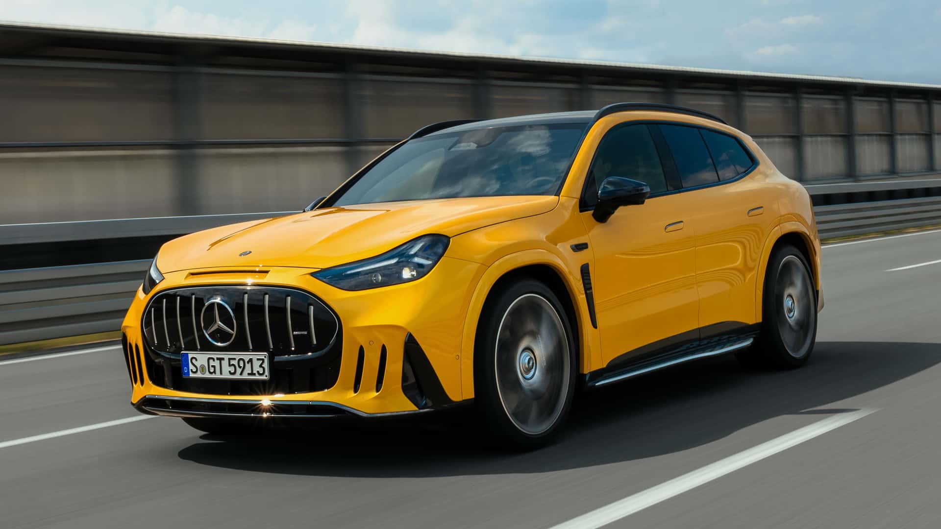 Yellow Mercedes-AMG GT SUV speeding along a highway, showcasing its aggressive grille and sporty luxury design