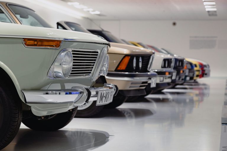 Multiple cars are standing in a closed parking with bright lights