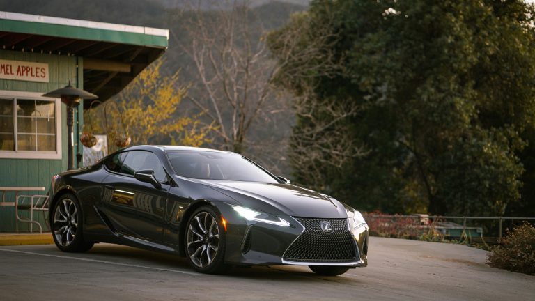 A Lexus is standing in front of a house in a small parking