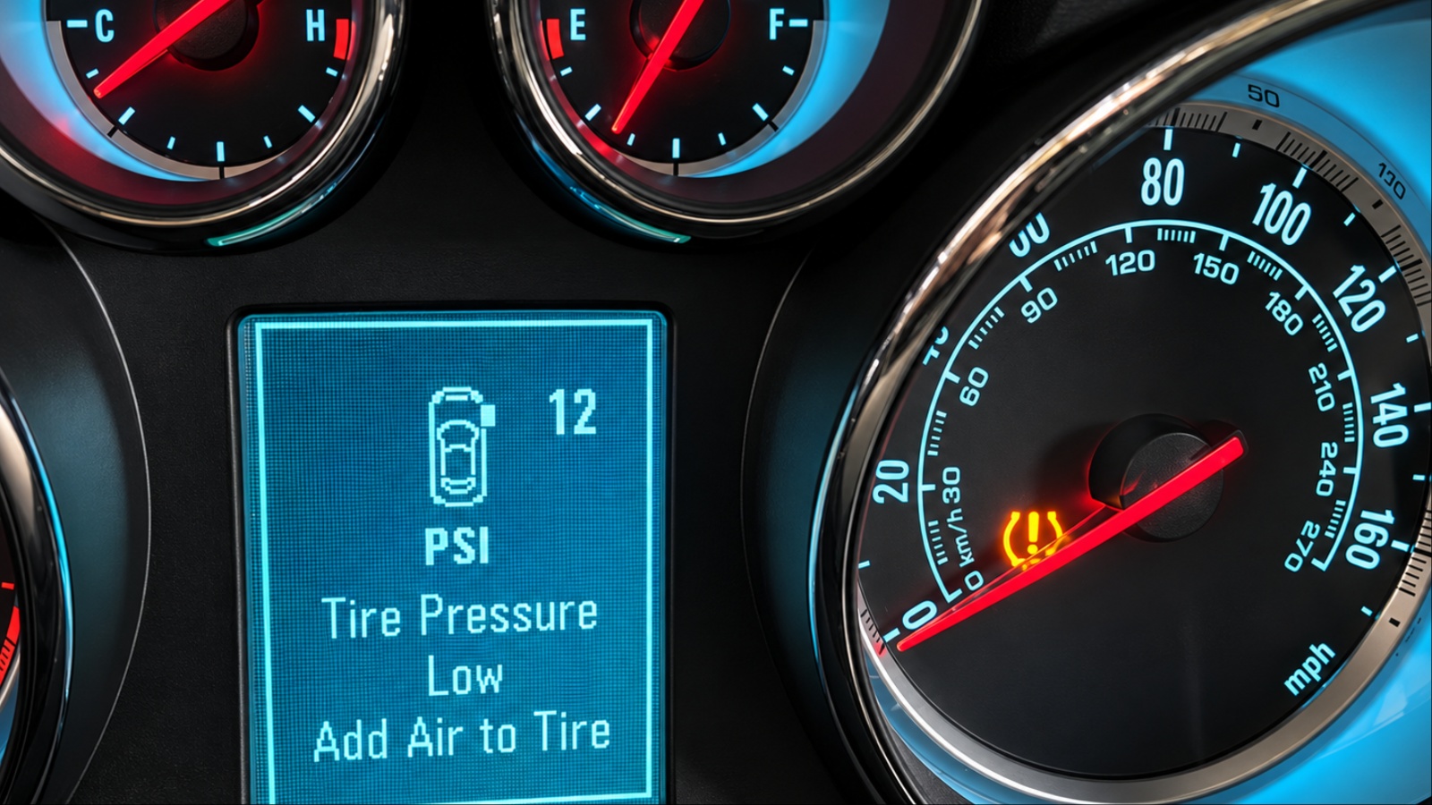 Dashboard displays a low tire-pressure warning alongside illuminated TPMS indicator