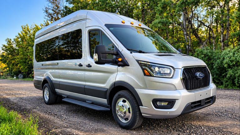 A Ford Transit is standing on a patchy road
