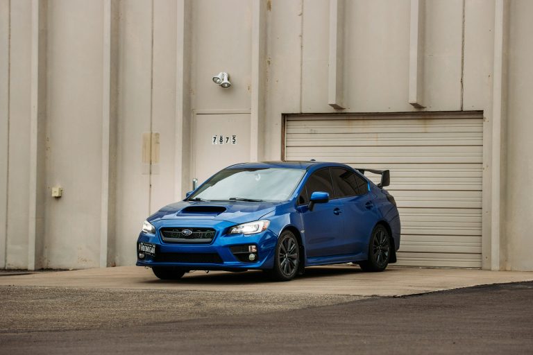 A Subaru is standing on a ramp outside a parking shutter