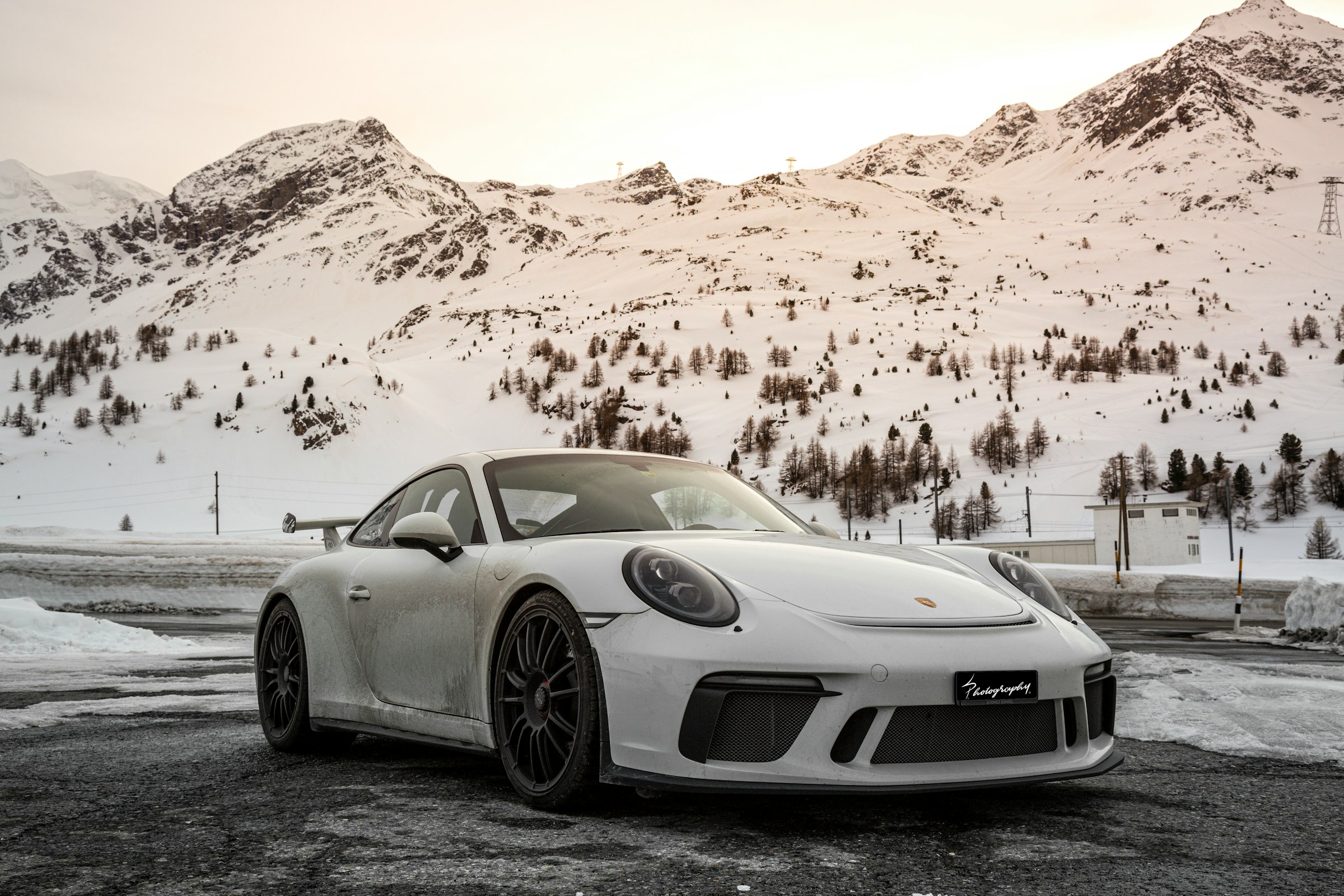 A Porsche is standing on a road on a snowy winter day
