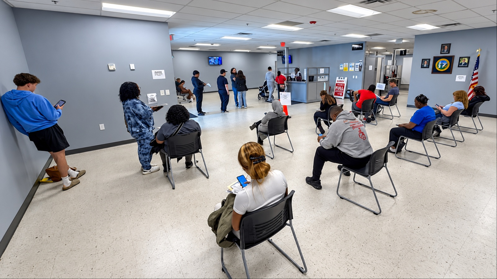 People waiting in chairs at busy DMV office interior