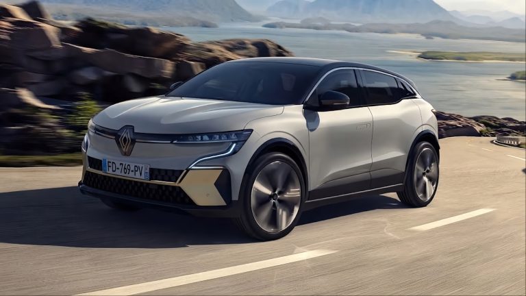 Renault Megane E-Tech Electric driving along a scenic mountain road beside a large lake
