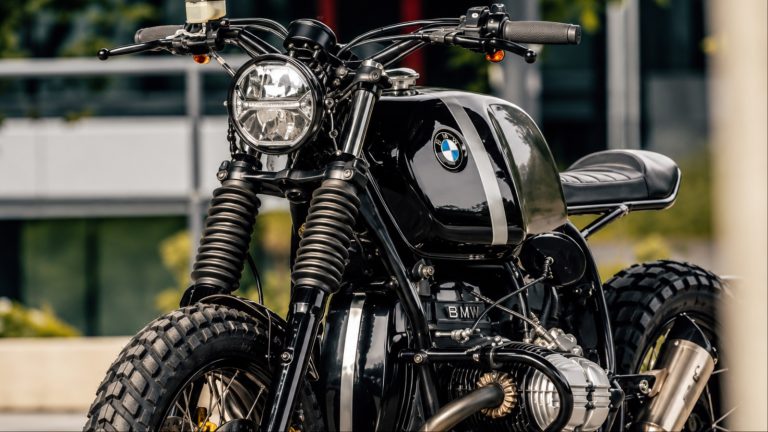Black customized vintage motorcycle with round headlight and knobby tires