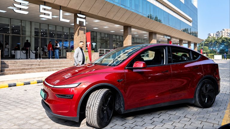 Tesla Model Y parked outside a modern showroom, highlighting its sleek electric crossover design