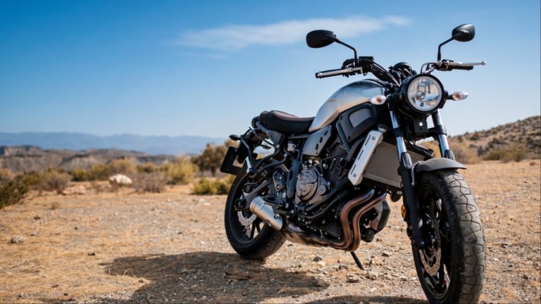 Silver Yamaha motorcycle parked on dry desert ground outdoors