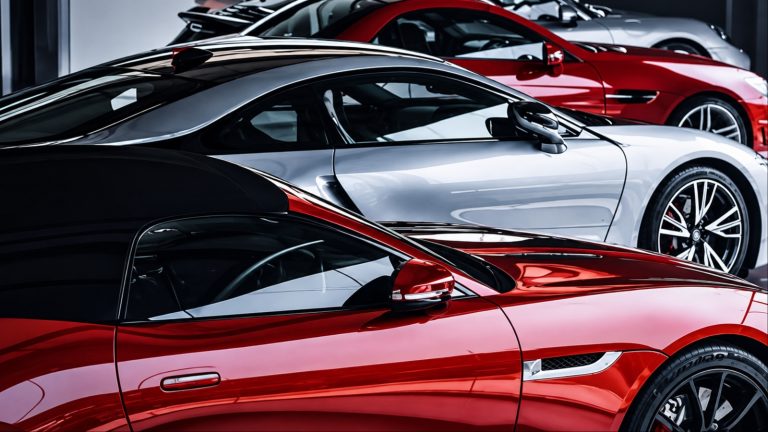 Luxury red and silver sports cars in modern showroom