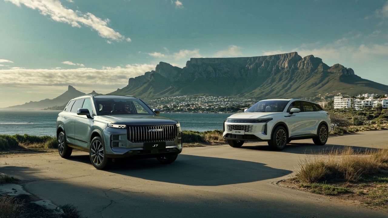 Two JAECOO SUVs parked beside Cape Town coastline beneath dramatic Table Mountain